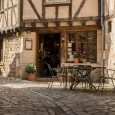 Enge Altstadtgasse mit historischem Gasthaus und Café in Fachwerk- und Steingebäuden